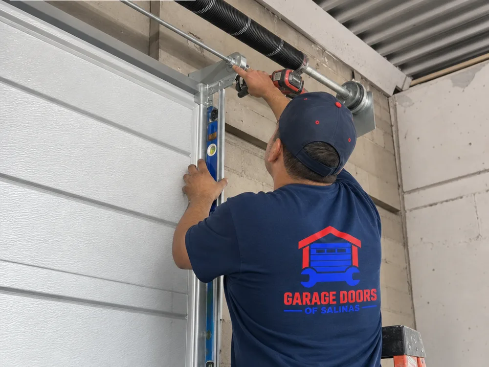 Contractor installing vertical track and a torsion shaft on a commercial sectional overhead door